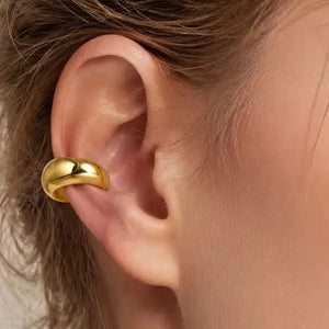 Paksu kullanvärinen ear cuff korvalehden reunassa
