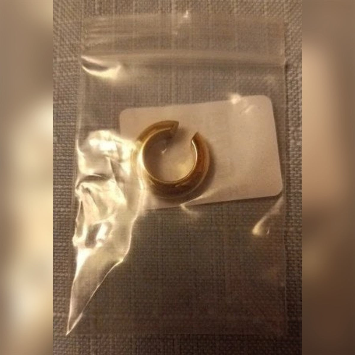 Ostajan kuva: kullanvärinen ear cuff pienessä minigrip-pussissa