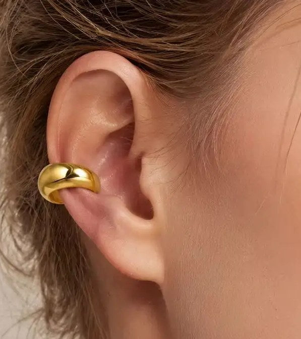 Paksu kullanvärinen ear cuff korvalehden reunassa