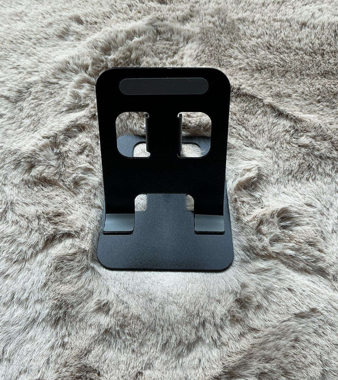 Musta taitettava tablettiteline auki pöydällä