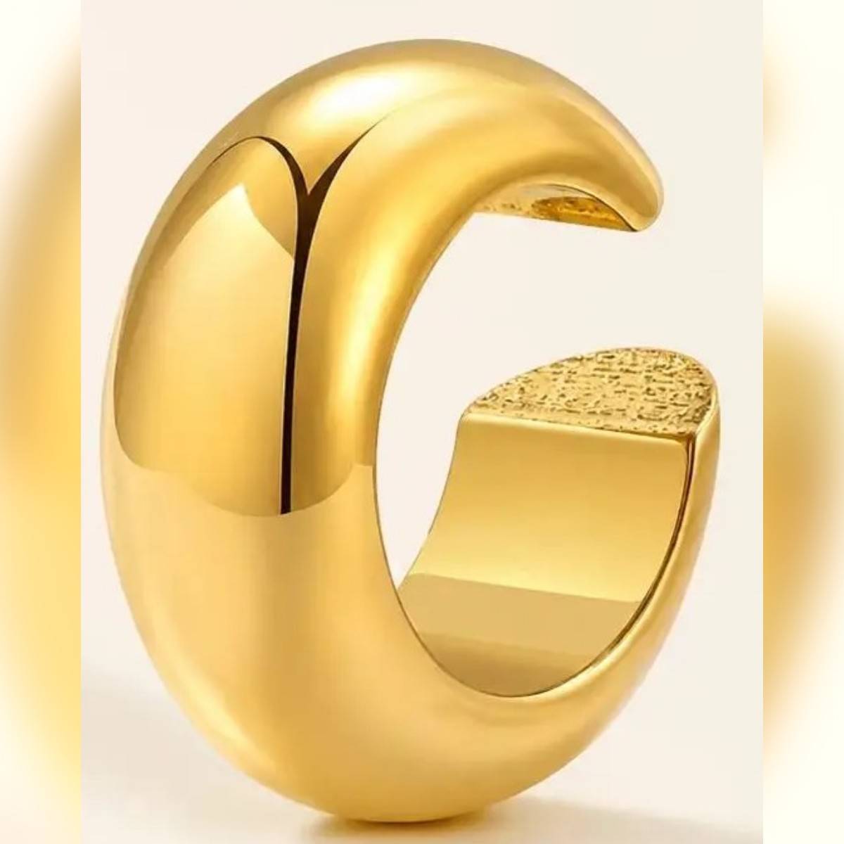 Kullanvärinen ear cuff vaalealla taustalla, C-muoto ja kupera pinta