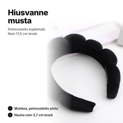 Musta pehmustettu hiusvanne kuplapinnalla, noin 17,5 cm leveä ja nauha noin 3,7 cm
