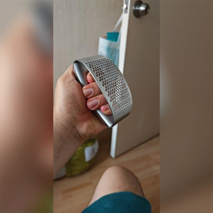 Ostajan kuva: valkosipulinpuristin kädessä