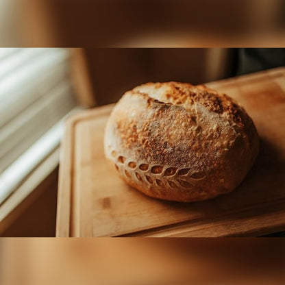 Ostajan kuva: pyöreä juurileipä, kohotettu korissa, leikkuulaudalla
